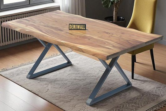 Wooden dining table with metal legs in a room with a chandelier and plant.