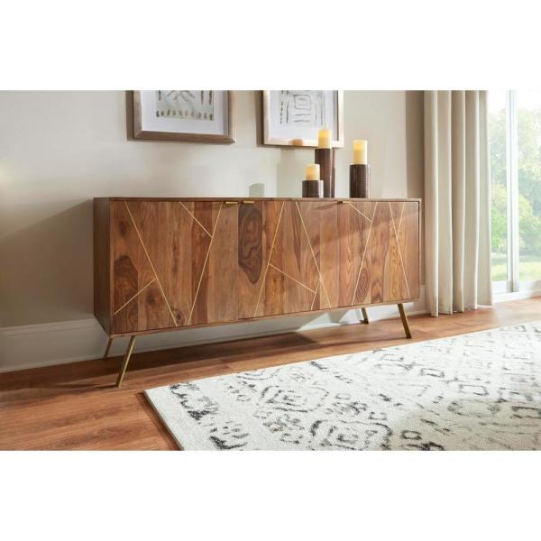 A mid-century modern wooden sideboard cabinet with geometric gold inlay on the doors, styled in a warm, decorated room with plants, books, and a small bicycle decor piece.